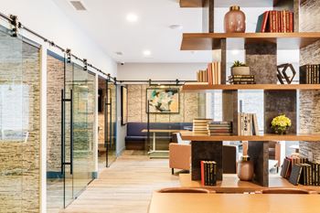 A living room with a table and shelves with books